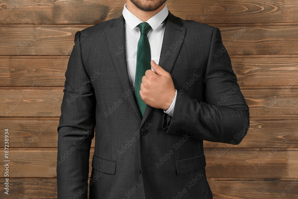 Handsome man in formal suit on wooden background, closeup
