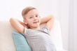© Africa Studio - Cute boy resting in armchair with soft pillow at home