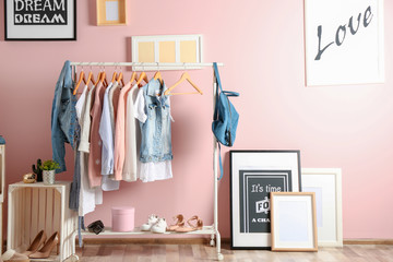 Collection of clothes hanging on rack in dressing room