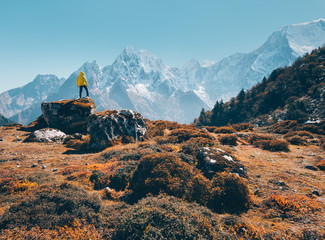Wall Mural - standing man on the stone and looking on amazing mountains at sunset. landscape with traveler, high 