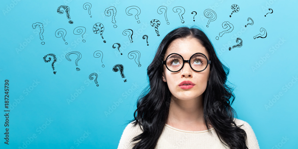 Young woman in a thoughtful pose with question marks - obrazy, fototapety, plakaty 