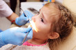 © Evgeniy Kalinovskiy - The dentist examines a child's teeth in a dental chair.