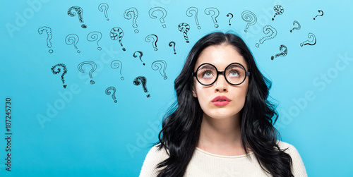 Fotografía Young woman in a thoughtful pose with question marks