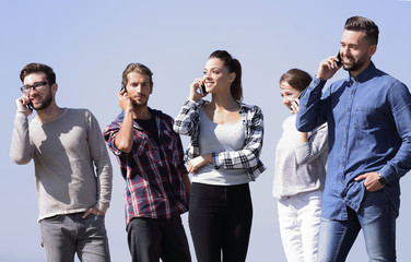 Wall Mural - group of students talking on their smartphones.