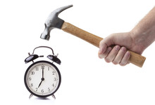 Men's Hand With Hammer Is Going To Break Alarm Clock Isolated On White Background