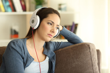 Wall Mural - Sad woman listening to music at home