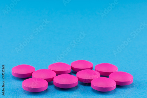 close up of pink round pills on blue background Tableau sur Toile