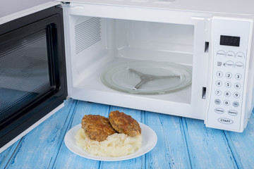 white microwave oven, on a blue wooden surface for heating food