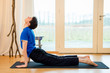 Man practicing yoga indoors in a retreat space doing Upward facing dog pose - urdhva mukha svanasana