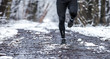 Legs of runner on snowy dirt, warm clothes for winter training