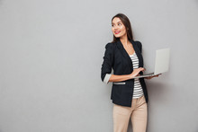 Smiling Asian Business Woman Holding Laptop Computer And Looking Back