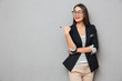 © Drobot Dean - Smiling asian business woman in eyeglasses pointing and looking away