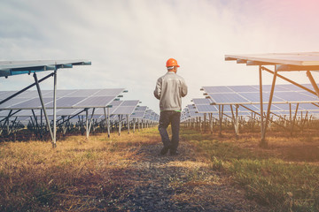 solar power plant to innovation of green energy; engineer or electrician working on checking and maintenance equipment at solar power plant