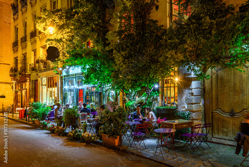 Cozy street with tables of cafe in Paris at night, France Poster