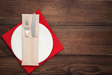 Fork and knife with napkin on white plate