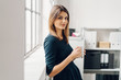 © contrastwerkstatt - Young woman with cup of beverage in office