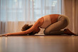 © Yakobchuk Olena - Low angle of peaceful young woman stretching her body while doing yoga exercise. She is kneeling on mat. Copy space