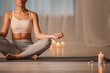 © Yakobchuk Olena - Tranquil girl is sitting on floor mat in lotus position. She is joining fingers and breathing with relaxation. Copy space