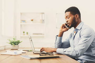 Wall Mural - Young black businessman talking on mobile phone