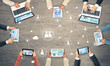 © adam121 - Top view of businesspeople sitting at table and using gadgets