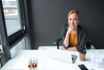 Aufkleber - Portrait of cheerful girl working with notebook computer in office. She looking at camera. Labor concept