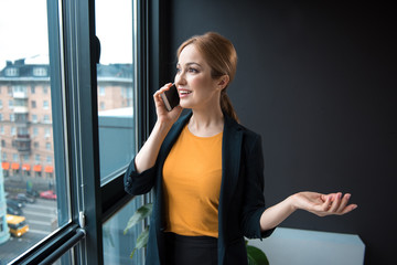 Poster - Portrait of beaming lady chatting by phone while looking at street. Communication and job concept