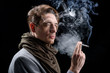 © Yakobchuk Olena - Miserable life. Side view of melancholic young stylish man is standing and smoking. He is looking aside wistfully while being in cloud of white smoke. Isolated background