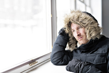 Wall Mural - Man With Warm Clothing Feeling The Cold Inside House close to a window