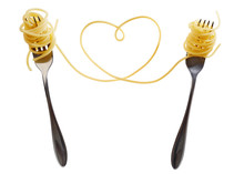 Swirls of cooked spaghetti with fork. Spaghetti heart shape.