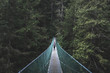 © Gary Parker/Stocksy - Girl standing on wooden bridge in forest