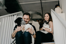 Young Couple Holding Pet Cats And Dogs