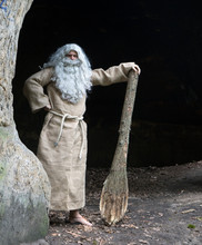 Bearded Hermit In A Cave Stands With Club In Hand