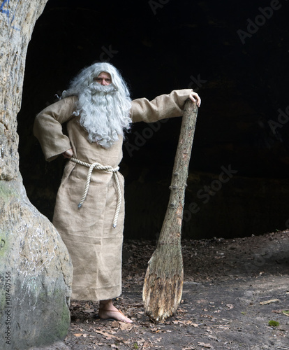 Cuadros en Lienzo bearded hermit in a cave stands with club in hand