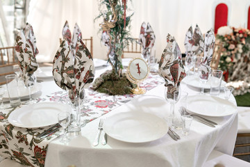 Interior of a wedding tent decoration ready for guests. Served round banquet table outdoor in marquee decorated flowers and silk. Catering concept