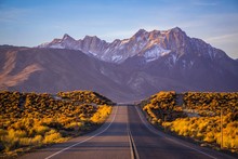 A Road In Eastern Sierra Leading Up To A Beautiful Snow Coverred Mountain With Morning Light