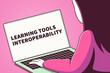 Woman looking at a laptop screen with the words learning tools interoperability