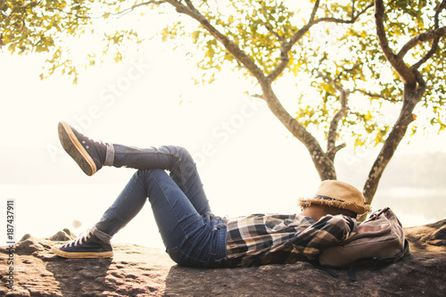 Fotografía Boy backpacker sleeping on the rock in nature , Relax time on holiday concept tr