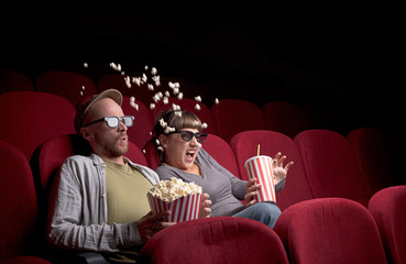 Wall Mural - Young couple sitting at red movie theatre