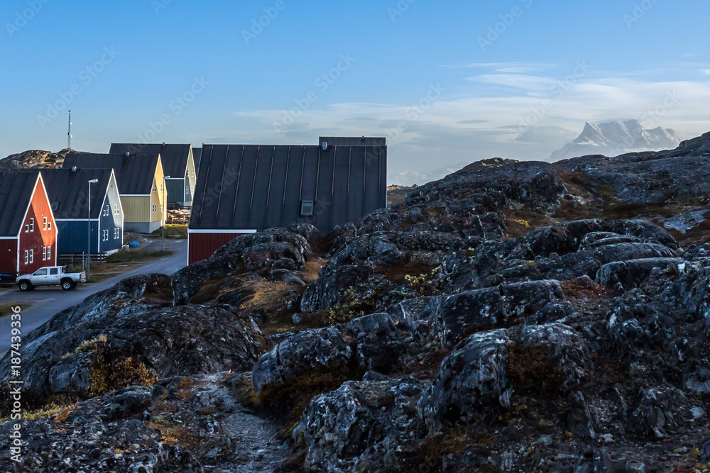 Memoriale Inuit Inuit houses along the street hidden in stones with Sermitsiaq mountain ...