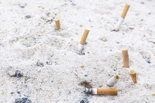 Tobacco Cigarette Butt On The Beach Sand.