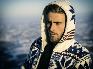 Wall Mural - Handsome young man outdoor in winter fashion, wearing black coat and woolen scarf in city park