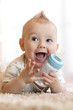 © Oksana Kuzmina - sweet baby holding bottle with water and smiling