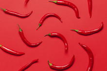 Red Chili Peppers Arranged On A Bright Red Background