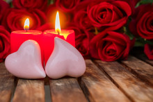Two Burning Candles With Fresh Roses