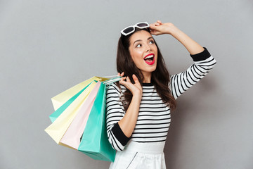 Wall Mural - Portrait of a cheerful woman holding shopping bags