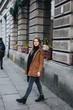 © Serhiy Hipskyy - Young pretty girl walk on the street. Hang her scarf in one hand and look around. Winter clothing with warm weather