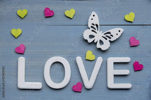 Love Weisse Schrift Weisser Schmetterling Und Pink Und Grune Herzen Auf Blau Gebeiztem Hintergrund Aus Holz Stock Photo Adobe Stock