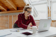 © epiximages - young, pretty, blonde woman is planning on the notebook and tablet the expansion of her loft