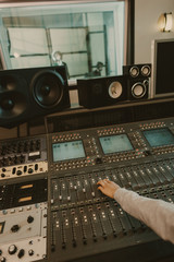 Poster - cropped shot of sound producer working with graphic equalizer at studio