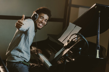 Wall Mural - happy young piano player showing thumb up